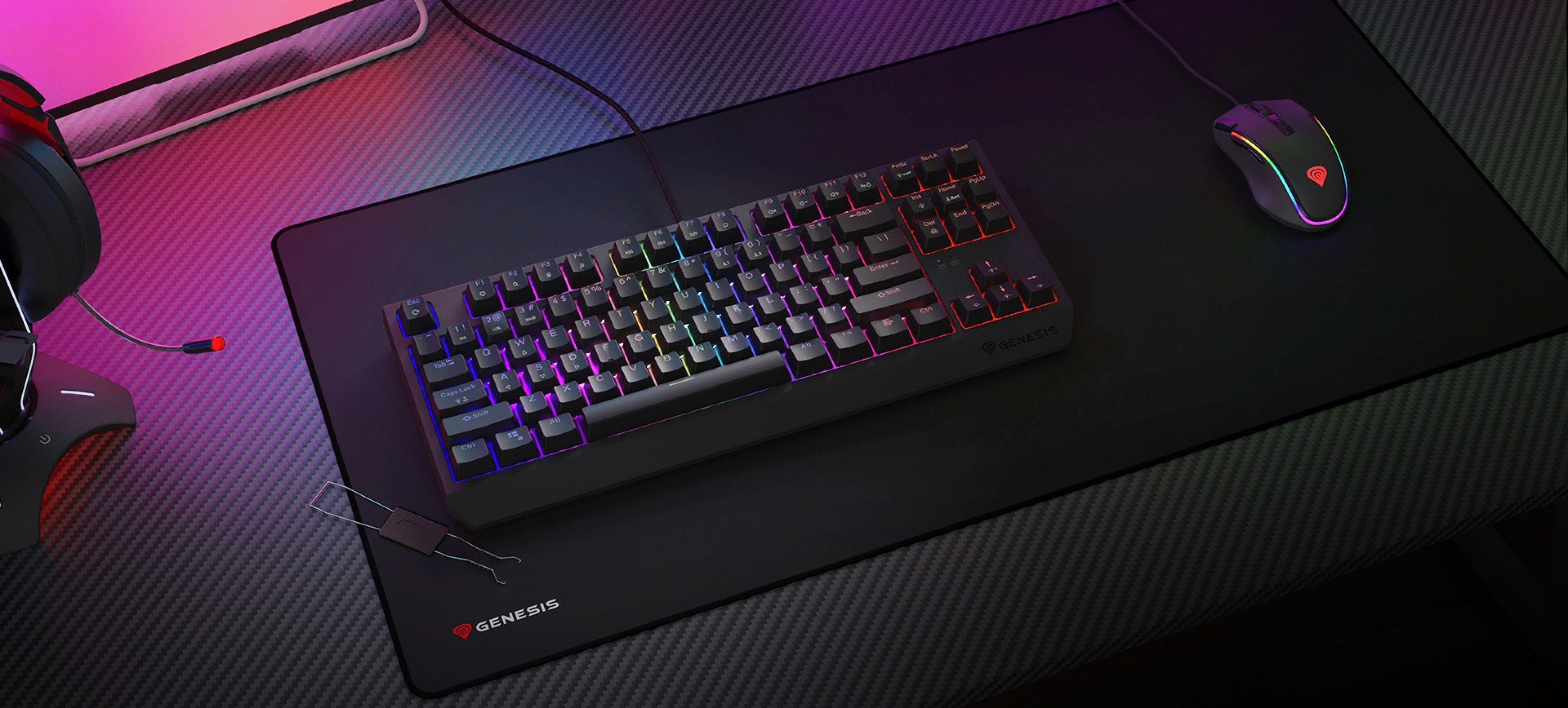 Tastatură mecanică de gaming cu iluminare RGB pe un mouse pad de gaming, însoțită de un mouse de gaming și căști