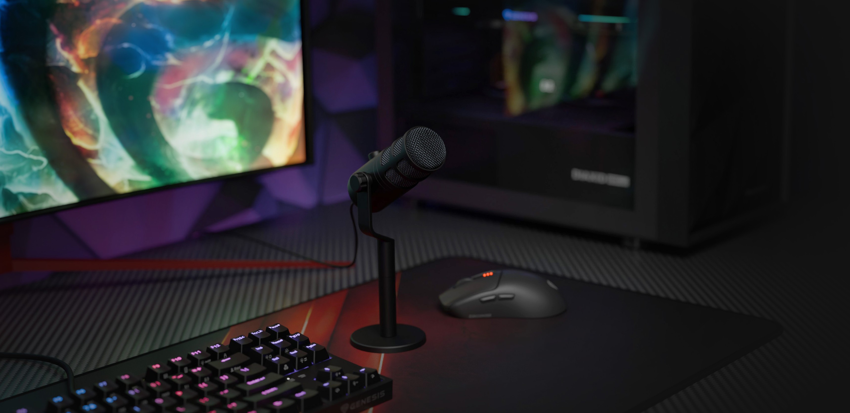 Microfon dinamic USB pe un suport cu o tastatură și un mouse, pe fundalul unui monitor de jocuri colorat